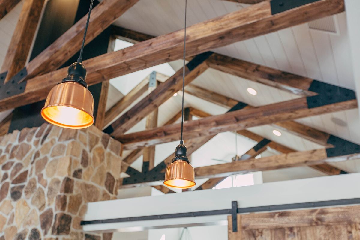 Attic room with wooden beams and warm pendant lights
